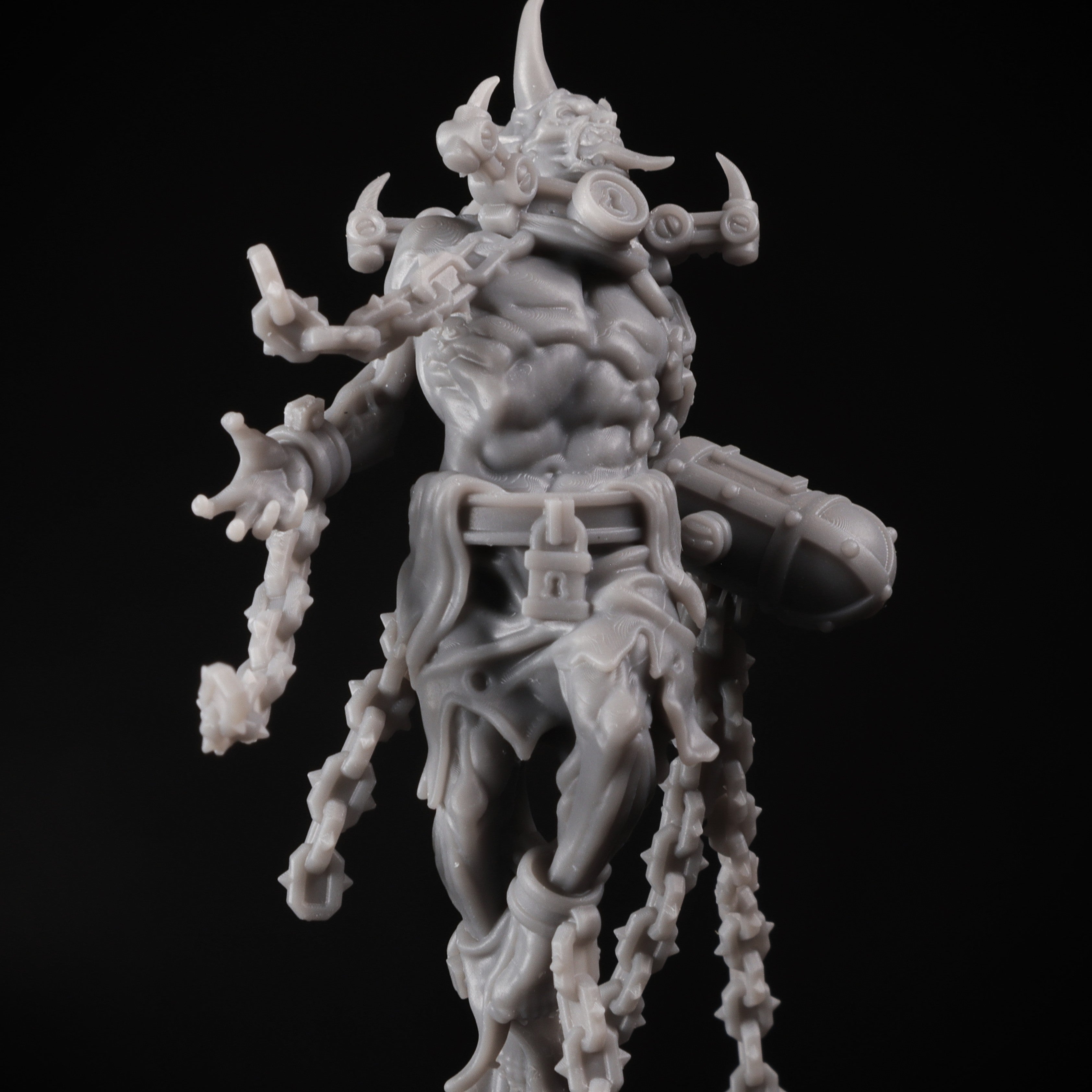 Gray figurine with detailed armor and weapons on a black background